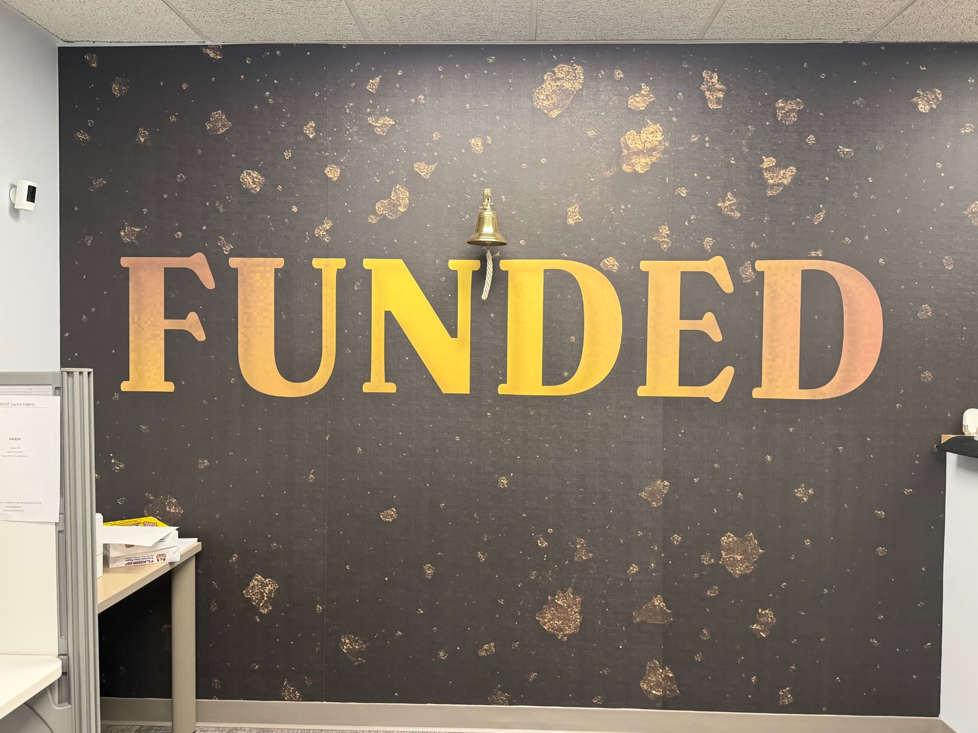 CamCap FUNDED gold lettering wall with the closing bell rung after every funded deal